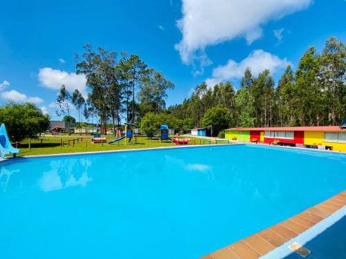 an empty swimming pool at a park with a playground at Bungalow 4x3 in Burinhosa
