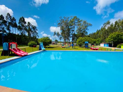 a swimming pool at a park with a playground at Bungalow 4x3 in Burinhosa