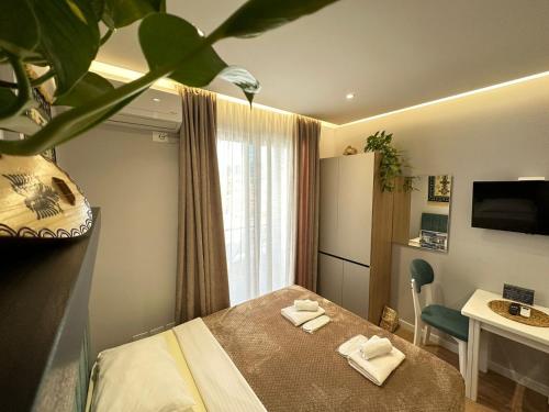 a hotel room with a bed and a table with towels at TreA Accomodations - Suite Lungomare in Vlorë