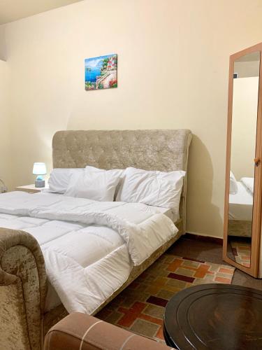 ein Schlafzimmer mit einem großen Bett mit weißer Bettwäsche in der Unterkunft Khalima food stuff building in Abu Dhabi