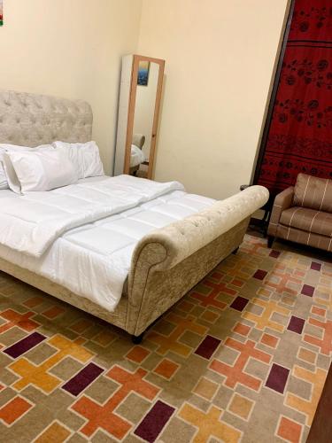 a bedroom with a large bed and a chair at Khalima food stuff building in Abu Dhabi