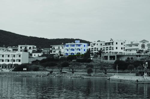 un gruppo di edifici bianchi accanto a un corpo idrico di Sunrise Studios a Megalochori (Isola di Agistri)