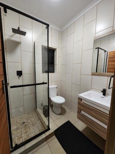 a bathroom with a shower and a toilet and a sink at Lloyds - 6 in Ermelo