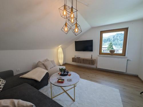 a living room with a couch and a table at Angerpartments-Sonnige große Wohnung mit Balkon und kostenlosen Parkplatz in Döbriach