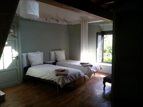 twee bedden in een kamer met een raam bij Bed In Bellongue in Aucazein