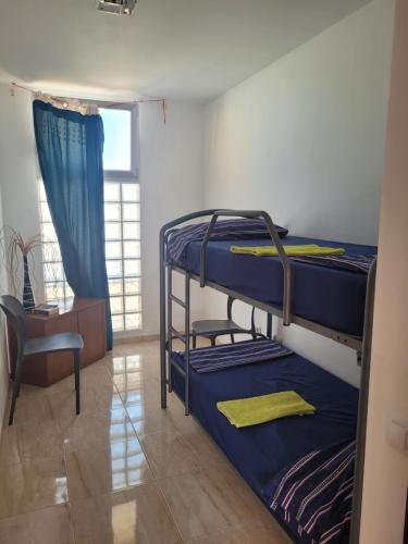 ビナロスにあるVilla Marinaの二段ベッド2台と椅子が備わる客室です。