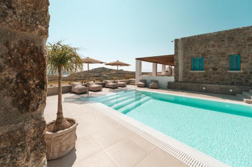 a villa with a swimming pool and a resort at Anemela Villas & Suites Mykonos in Agrari