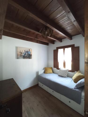 1 dormitorio con cama y ventana en Aromas de Coraín, en Cangas de Onís