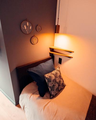 a bedroom with a bed with a pillow on it at La Petite Bélérit, maison de ville - Landerneau in Landerneau