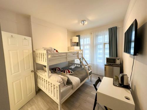 sypialnia z łóżkiem piętrowym i biurkiem w obiekcie Pink Door Guesthouse w Londynie
