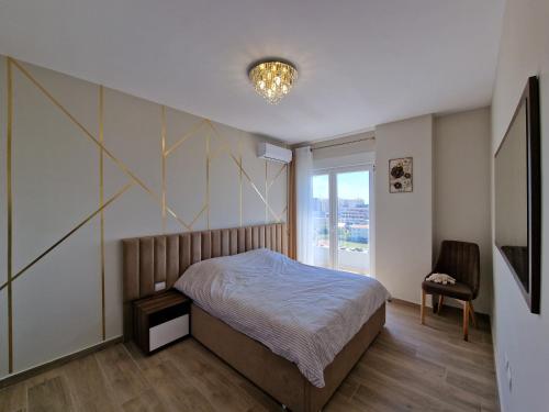 a bedroom with a bed and a large window at Anchor Apartments in Shëngjin