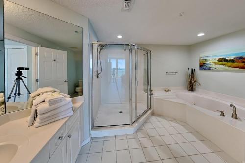 a bathroom with a shower and a tub and a sink at The Pearl Of Navarre 705 in Navarre