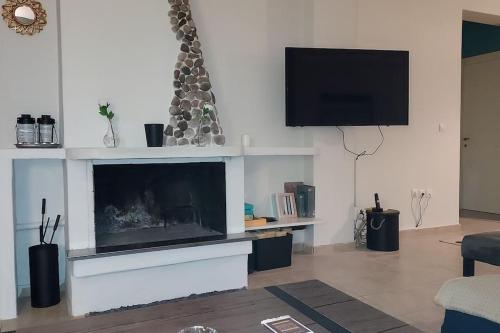 sala de estar con chimenea y TV de pantalla plana en Aegina luxury apartments, en Aegina Town