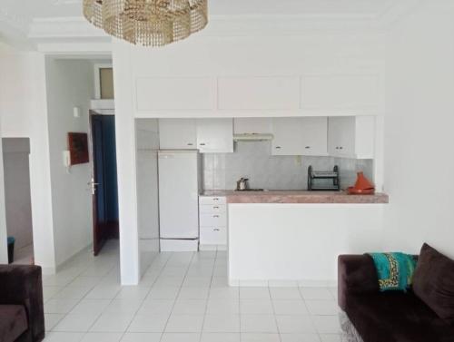 Il comprend une cuisine avec des placards blancs et du carrelage blanc. dans l'établissement Superbe appartement pied et vue sur mer, à Taghazout