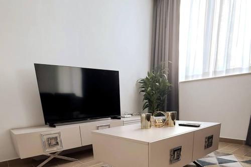 a living room with a flat screen tv on a wall at Luxury apartment in Yas Island in Abu Dhabi