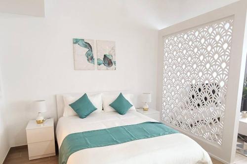 a white bedroom with a bed with blue pillows at Luxury apartment in Yas Island in Abu Dhabi