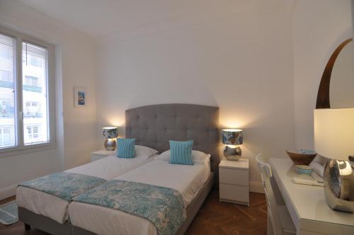 a bedroom with a bed with blue pillows and a desk at Palais Albert . 2-Bedroom Apartment -Ponteil Beach in Antibes