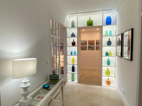 a hallway with a shelf of vases on the wall at Palais Albert . 2-Bedroom Apartment -Ponteil Beach in Antibes