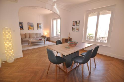 un salon avec une table et des chaises en bois dans l'établissement Palais Albert -2-Bedroom Apartment -Ponteil Beach -StayInAntibes, à Antibes