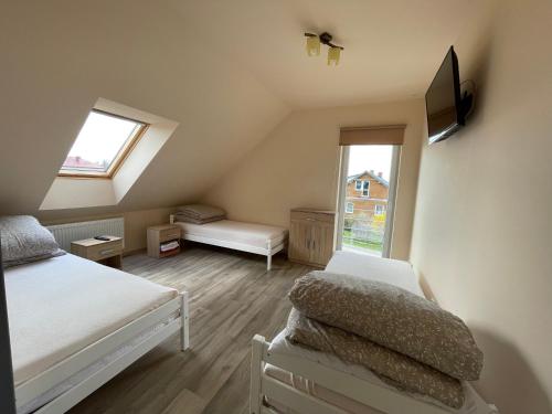 a attic bedroom with two beds and a tv at Noclegi Długie in Długie