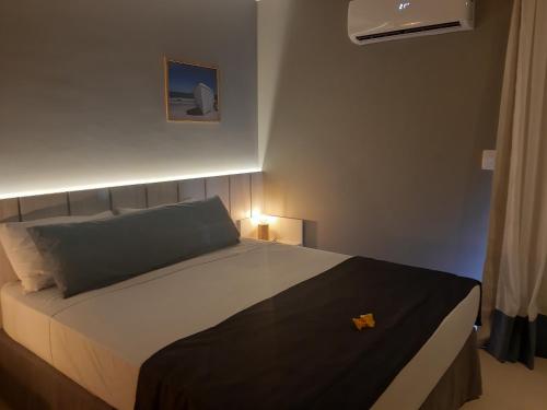 Un dormitorio con una cama grande con luz. en Flat Samba en Cabo Frío