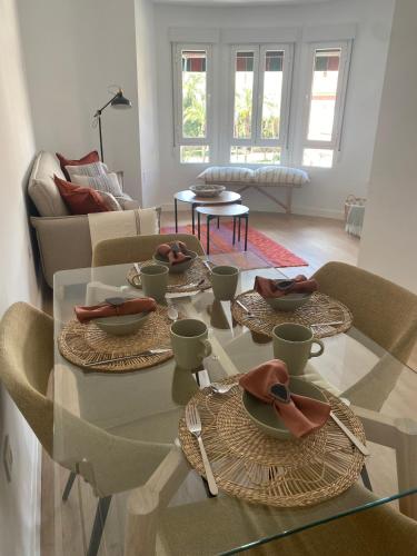 ein Wohnzimmer mit einem Glastisch mit Geschirr darauf in der Unterkunft Apartamento La Muralla in Talavera de la Reina