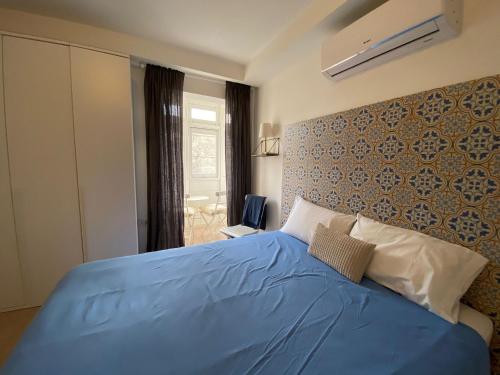 a bedroom with a blue bed with a wall at Cozy 2 bedroom Apartment near Seafront in Il-Gżira