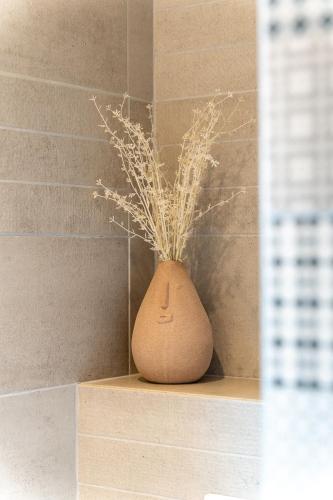 a vase with grass in it sitting on a shelf at Vakantiewoning De Bles in Avelgem