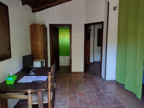 Habitación con escritorio, ordenador y paredes verdes. en Cabaña rural la Dehesa 2, en Riópar
