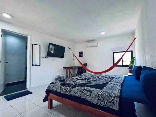 - une chambre avec un lit et une télévision à écran plat dans l'établissement La Perle Noire - Auberge, à Cozumel