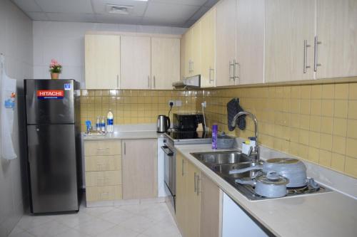 a kitchen with a black refrigerator and a sink at Luxurious Private Beach & Pool, fully Furnished 1BR Apartment at Marjan Island Ras al khaimah in Ras al Khaimah