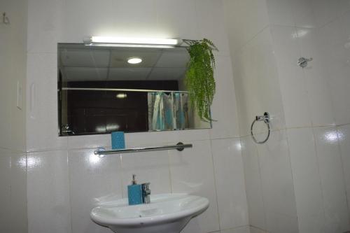 a white bathroom with a sink and a mirror at Luxurious Private Beach & Pool, fully Furnished 1BR Apartment at Marjan Island Ras al khaimah in Ras al Khaimah