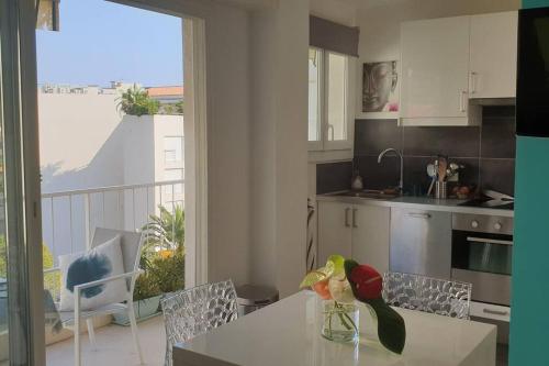 uma cozinha com uma mesa com um vaso de flores em Centre et plage tout à pied échappée mer em Cannes