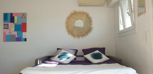 um quarto com uma cama com almofadas e um espelho em Centre et plage tout à pied échappée mer em Cannes