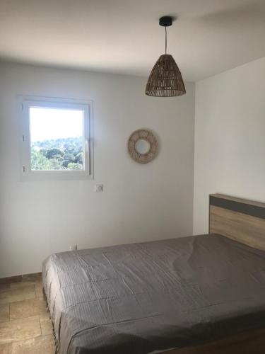 biała sypialnia z łóżkiem i oknem w obiekcie Mini villa proche des plus belles plages w mieście Porto-Vecchio