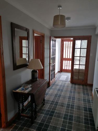 a room with a table with a lamp on it at Brackenbrae Holiday Cottage in Acharacle