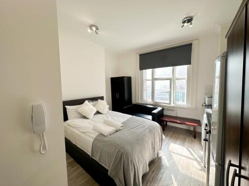 una camera bianca con un letto e una finestra di the upper floor a Croydon