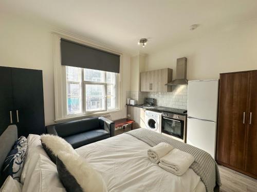 a kitchen with a large white bed in a room at the upper floor in Croydon