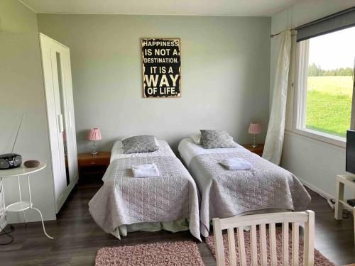 a bedroom with two beds and a sign on the wall at Huoneistomajoitus Tupa,LaatuLomat in Juva