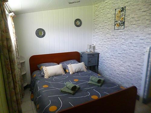 a bedroom with a bed with pillows on it at gite du guip in Trégourez