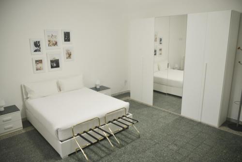 ein weißes Schlafzimmer mit einem Bett und einem Spiegel in der Unterkunft La Casa di Eva in Brindisi