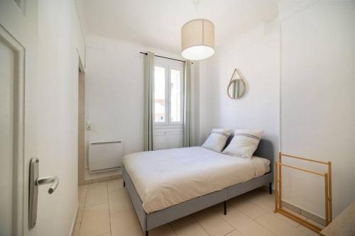 a bedroom with a bed with white sheets and a window at Appartement tout équipé balcon 4 pers St Charles in Marseille