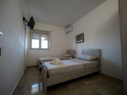 een slaapkamer met 2 bedden en een raam bij Carlitos in Realmonte