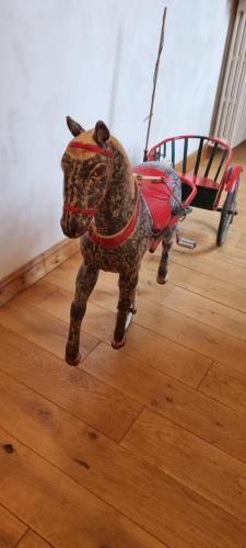 a toy horse pulling a cart on a wooden floor at Chateau de Cadars in Quins