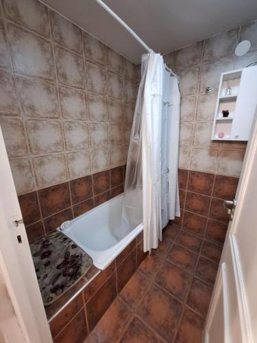 y baño con bañera y ducha. en Familiar, cómodo y bien ubicado en Mendoza