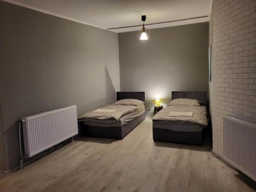 a room with two beds and a brick wall at Pokoje pracownicze Witkowska in Gniezno