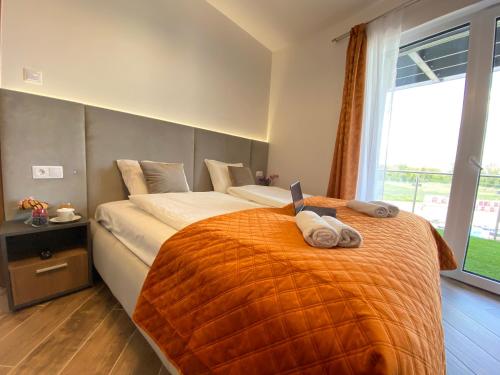 Un dormitorio con una cama con una computadora portátil encima. en Dandelion Royal Homes, en Keszthely