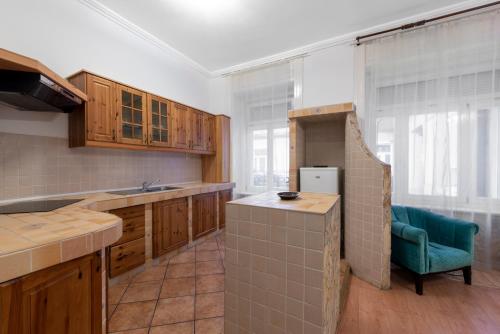 a kitchen with wooden cabinets and a blue chair at Baross City Hotel - Budapest in Budapest