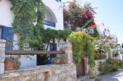a house with flowers and a wooden fence at Nostos Studios in Aegiali