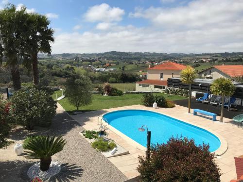 a swimming pool in a yard with a house at Casa o Futuro in Alcobaça